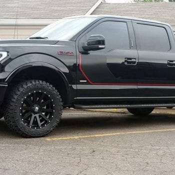 Black truck with custom black rims and red accents