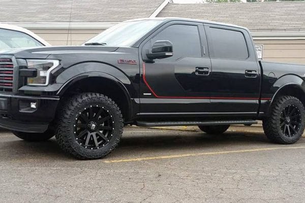 Black truck with custom black rims and red accents